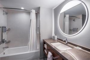 a bathroom with a tub and a sink and a mirror at Courtyard by Marriott Conway in Conway