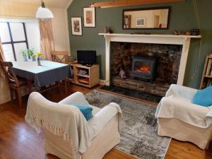 a living room with a fireplace and a table and chairs at The Ruah - Clifftop Retreat in Whitehall
