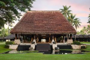 a resort with a thatched roof and a pond at The Westin Denarau Island Resort & Spa, Fiji in Denarau