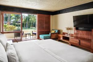 um quarto com uma cama, uma televisão e uma cadeira em The Westin Denarau Island Resort & Spa, Fiji em Denarau