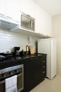 a kitchen with a black counter top and a refrigerator at Art Inn Porto in Rio de Janeiro