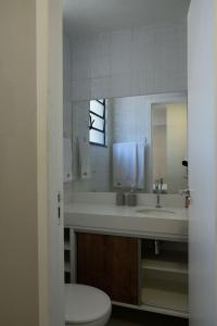 a bathroom with a sink and a toilet and a mirror at Art Inn Porto in Rio de Janeiro