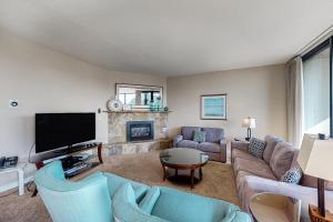 a living room with a couch and a tv at Sand & Sea: Paradise on the Prom (516) in Seaside