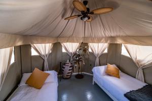 a room with two beds and a ceiling fan at El Toril Glamping Experience in Parrillas