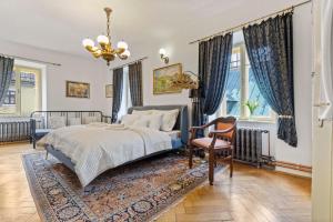 a bedroom with a bed and a chair and windows at Vila Štiavnica in Banská Štiavnica
