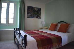 1 dormitorio con 1 cama con manta y ventana en L'Occitania Chambre d'hotes en Puivert