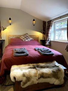 1 dormitorio con 1 cama con toallas en Charming, rustic & well equipped garden cottage, en Alyth