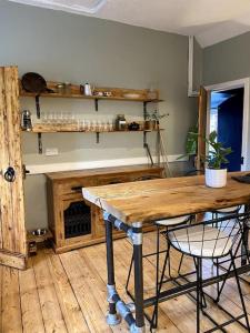 a kitchen with a table and chairs and a fireplace at Charming, rustic & well equipped garden cottage in Alyth