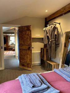 a bedroom with a bed and a closet with a robe at Charming, rustic & well equipped garden cottage in Alyth
