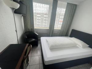 ホーホハイム・アム・マインにあるHotel & Restaurant Main Taunusのベッド、デスク、窓が備わる小さな客室です。