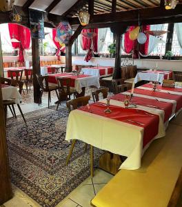 a row of tables in a restaurant with red table cloth at Hotel & Restaurant Main Taunus in Hochheim am Main