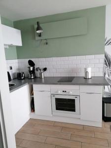 kuchnia z białymi blatami i piekarnikiem w obiekcie Studio Quiberon au Calme à 200 m de L embarcadère w mieście Quiberon