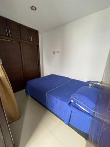 Dormitorio pequeño con cama azul y armario en Medellin cerca a plaza mayor, en Medellín