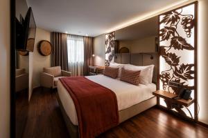 ポルトにあるTURIM Oporto Hotelのベッドと椅子のあるホテルの部屋