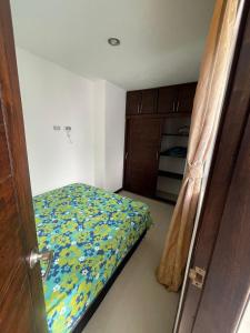 um pequeno quarto com uma cama e uma porta em Medellin cerca a plaza mayor em Medellín