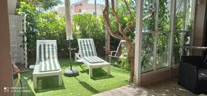 ウッジャーノ・ラ・キエーザにあるBellissima casa a pochi passi da Otrantoの庭の芝生に座る白い椅子2脚