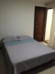 - un grand lit dans une chambre avec une porte dans l'établissement Medellin cerca a plaza mayor, à Medellín