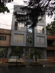 un bâtiment avec des palmiers en face de celui-ci dans l'établissement Medellin cerca a plaza mayor, à Medellín