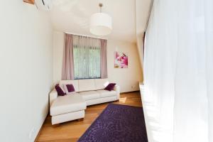 ein Wohnzimmer mit einem weißen Sofa und einem lila Teppich in der Unterkunft Apartamenty Sun & Snow Ciągłówka in Zakopane
