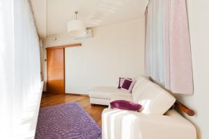 ein Wohnzimmer mit einem weißen Sofa und einem lila Teppich in der Unterkunft Apartamenty Sun & Snow Ciągłówka in Zakopane