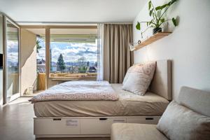 een slaapkamer met een bed, een bank en een raam bij Ferienwohnung Bodensee in Lindau