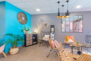 Cette chambre est dotée de murs et de chaises bleus ainsi que d'un miroir. dans l'établissement Appart'City Confort Toulouse Aéroport Cornebarrieu, à Cornebarrieu