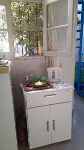 Una cocina con gabinetes blancos y una ventana. en Campanita amarilla, en Salta