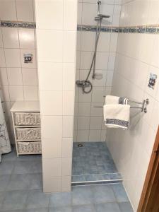 uma casa de banho com um chuveiro com azulejos brancos em Töpferweg 06 Ferienwohnung Tine em Ahrenshoop