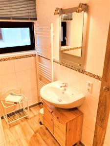 uma casa de banho com um lavatório e um espelho em Töpferweg 06 Doppelhaushälfte Mia em Ahrenshoop