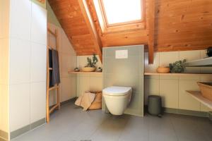 bagno con servizi igienici e soffitto in legno di Haus Bodderbloom, App 02 a Dierhagen Altre 10 foto