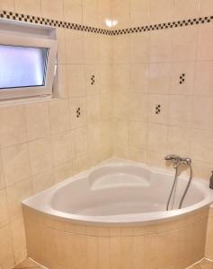 a bath tub in a bathroom with a window at Jenny Apartment with Jacuzzi in Brezovica