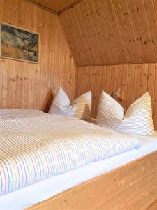 - une chambre avec un lit dans une cabane en bois dans l'établissement Töpferweg 06 Georgia, à Ahrenshoop