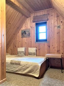 a bed in a wooden room with a window at Töpferweg 06 Georgia in Ahrenshoop