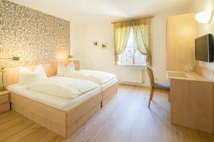 a bedroom with a bed and a desk and a television at Land-gut-Hotel Lohmann in Drensteinfurt