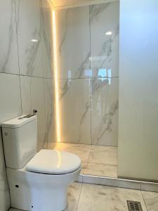 a bathroom with a white toilet and a shower at Yamina Rooftop Residence in Agia Pelagia