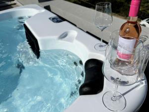 a bath tub with a bottle of wine and two glasses at Yamina Rooftop Residence in Agia Pelagia +7 photos