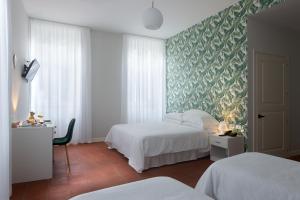 una camera d'albergo con due letti e una parete verde di Palazzo Sant'Antonio a Napoli