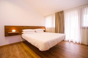 um quarto com uma cama grande com lençóis brancos e almofadas em ARIA - Villa di Campagna em Montecorvino Rovella