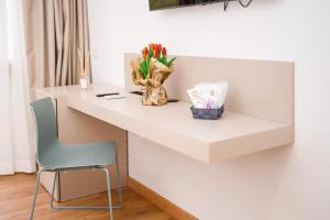 een wit bureau met een stoel en een vaas met bloemen bij ARIA - Villa di Campagna in Montecorvino Rovella