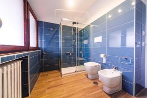 een blauwe betegelde badkamer met een toilet en een douche bij ARIA - Villa di Campagna in Montecorvino Rovella