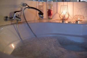 a bath tub filled with water with a faucet at Casa Quimera in Gilgarcía