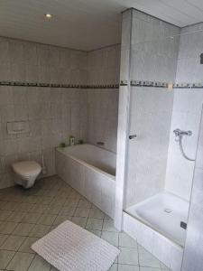 ein Badezimmer mit einer Badewanne, einem WC und einer Badewanne in der Unterkunft ElHa's FeWo in Gladbeck