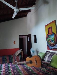 a guitar sitting on a bed in a room at Cafetín-Hostal Rincón NICA in Granada