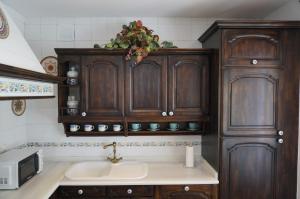 uma cozinha com armários de madeira e um lavatório em A Casa do Choco em Redondela