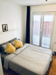 1 dormitorio con 1 cama grande y 2 almohadas amarillas en Jenny Apartment with Jacuzzi, en Brezovica