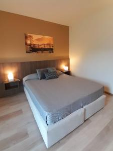 a large bed in a bedroom with two lamps at Prealpina Hotel in Bagnolo Piemonte