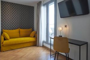 a living room with a yellow couch and a table at HOTEL ARRIZUL CATEDRAL in San Sebastián