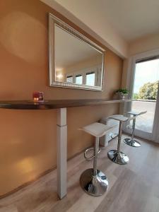 einen Waschtisch mit einem Spiegel und Hockern in einem Zimmer in der Unterkunft Prealpina Hotel in Bagnolo Piemonte