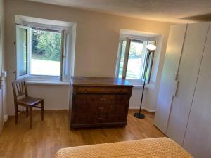 um quarto com uma cómoda em madeira e 2 janelas em Casa Luciana nel cuore dell'Alpe(022102-AT-849663) em Bertoldi