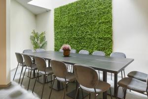 HOTEL ARRIZUL CATEDRAL في سان سيباستيان: قاعة اجتماعات مع طاولة وكراسي وجدار أخضر
